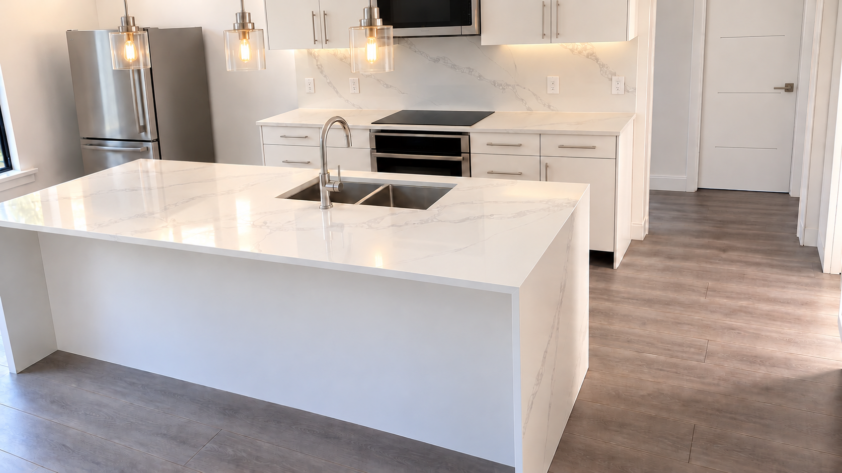 White kitchen with a large island and pendant lighting